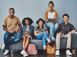 Five youth seated appearing confident depicting effects of leadership training programs for youth as supported by youth leadership research.