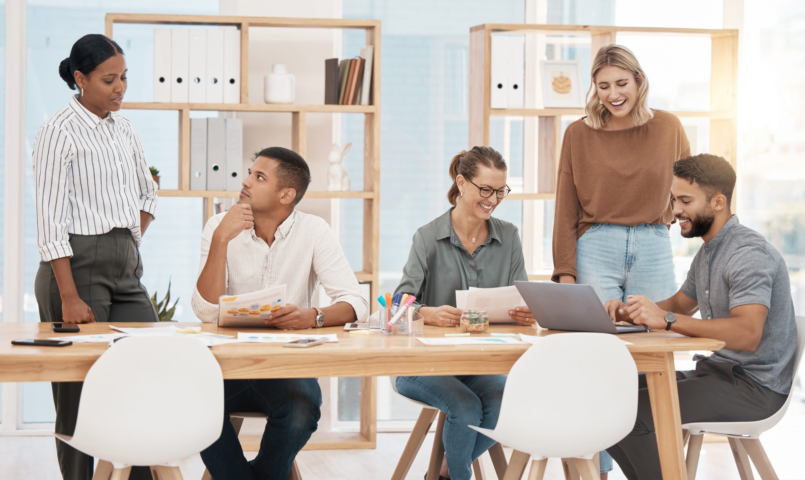 Young adults in modern office environment collaborating during confidence building programs for young adults and teen confidence workshop